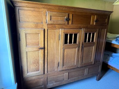 un grand meuble en bois dans le coin d'une pièce