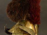 helmet of a man with a red feather on top of it