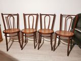 four wooden chairs sitting next to each other on a hard wood floor