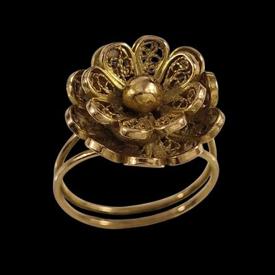 une image représentant une bague en or avec une fleur au centre