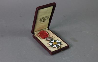 medal in a wooden box on a gray surface with a red ribbon