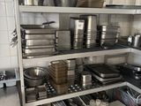 de nombreuses casseroles et poêles sur les étagères de la cuisine