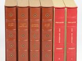 plusieurs livres sont alignés sur une surface blanche