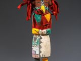 une statue en bois représentant un Amérindien orné de plumes colorées