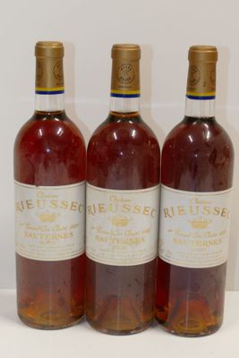 trois bouteilles de vin posées sur une table, l'une à côté de l'autre