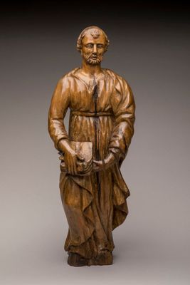 une statue en bois représentant un homme coiffé d'un chapeau et vêtu d'une robe