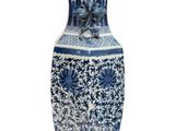 a blue and white vase sitting on a white surface