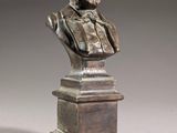 a bronze bust of a man with a beard on a pedestal