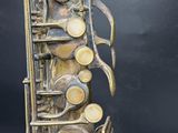 a close up of a saxophone on a black background with a black background