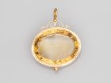 un pendentif en or jaune orné d'une grande pierre facettée entourée de diamants
