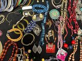 many different types of necklaces and bracelets laid out on a table
