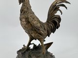 statue d'un coq debout sur un rocher, sur fond blanc