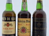 trois bouteilles de vin sont alignées sur une surface blanche