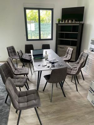 plusieurs chaises disposées autour d'une table sur laquelle est posé un ordinateur portable