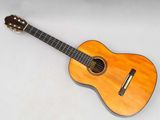 a close up of an acoustic guitar on a white surface