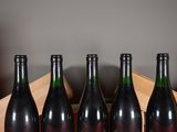 four bottles of wine sit in a wooden crate on a table