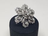 a close up of a diamond flower ring on a black ring box