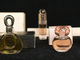 several different perfume bottles are lined up on a black surface