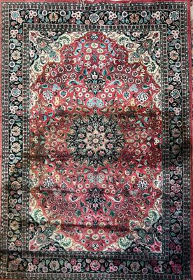 a red and black rug with a medallion design on it