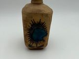 a small bottle with a blue flower on it