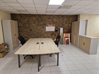 une pièce équipée d'une table, de chaises et d'un réfrigérateur