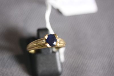 an image of a gold ring with a blue stone