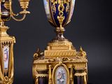 two gold and blue vases sitting on a black table