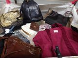 many bags and purses in a suitcase on the floor