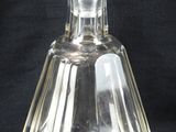 une bouteille en verre transparent munie d'un bouchon, sur fond noir