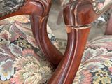 a close up of a pair of chairs with a floral upholstered back