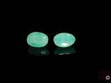 a pair of green jade stone earrings on a black surface