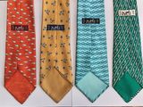 several ties with different designs are lined up on a white surface