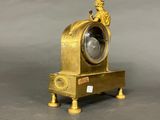 a gold clock with a statue on top of it