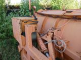 a large orange machine that is sitting in the grass
