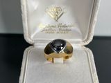a gold ring with a black stone inside of it