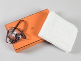 une boîte orange contenant une paire de lunettes et une paire de chaussettes blanches
