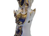a white vase with a blue and gold decoration on it