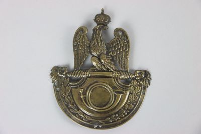 a metal badge with two birds on it on a white surface