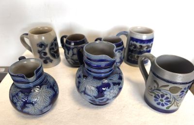 Plusieurs vases bleus et blancs sont alignés sur une table