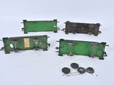 four pieces of green and black train cars sitting on a white surface