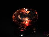 an orange diamond on a black surface with a black background