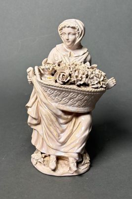 figurine of a woman holding a basket of flowers
