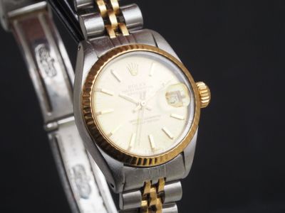 une montre-bracelet en or et en argent avec un cadran blanc