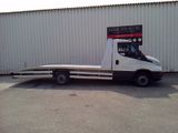 a white truck with a flat bed parked in front of a building