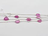 un gros plan d'un collier orné de pierres roses sur fond blanc