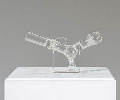 une pipe en verre posée sur une boîte blanche