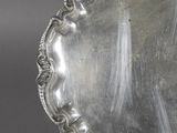 an antique silver plate with a decorative design on the rim