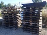 several wooden pallets stacked on top of each other on a gravel ground