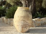 a large stone vase sitting in the middle of a garden