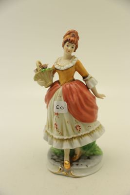 une figurine représentant une femme tenant un panier de fleurs